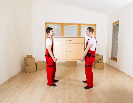 Removal team carrying items through a Docklands building corridor